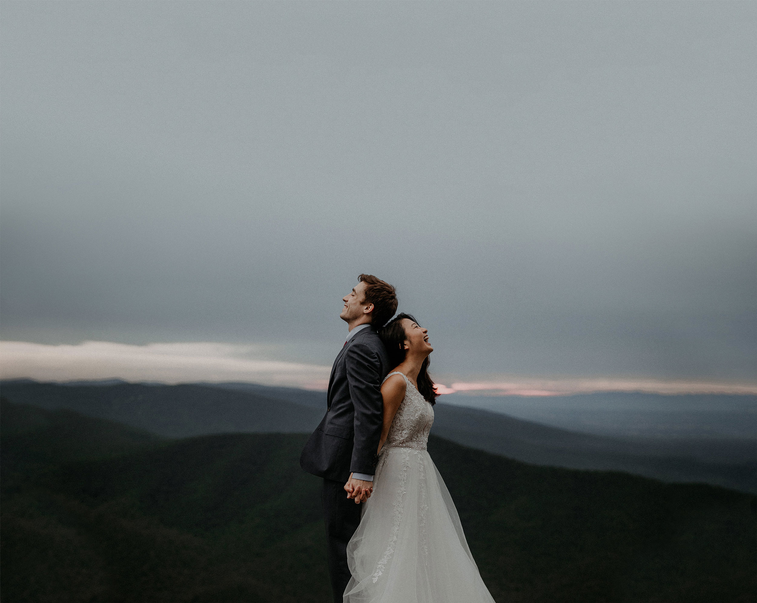 eloping couple laughing in mountains