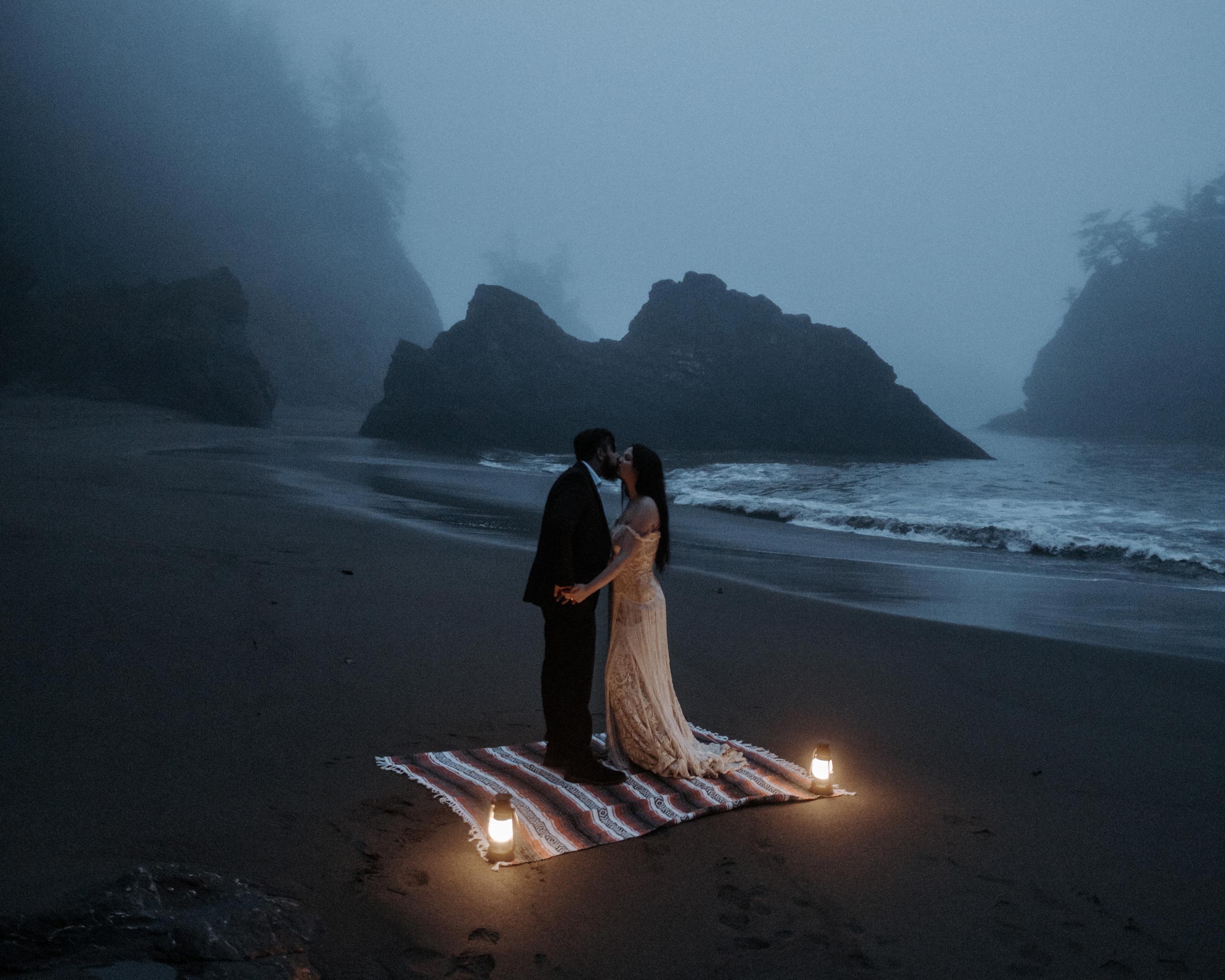 a wedding couple kissing on a foggy moody oregon beach