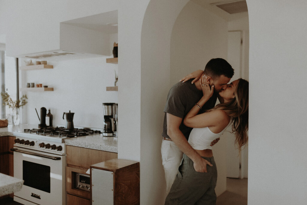 A man and woman kissing in a clean, modern airbnb called Le Chacuel in Joshua Tree.