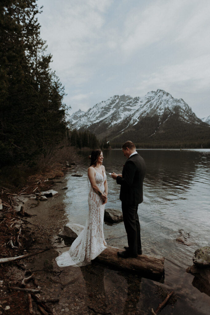 An elopement couple saying their vows at Leigh Lake at Grand Teton National Park.