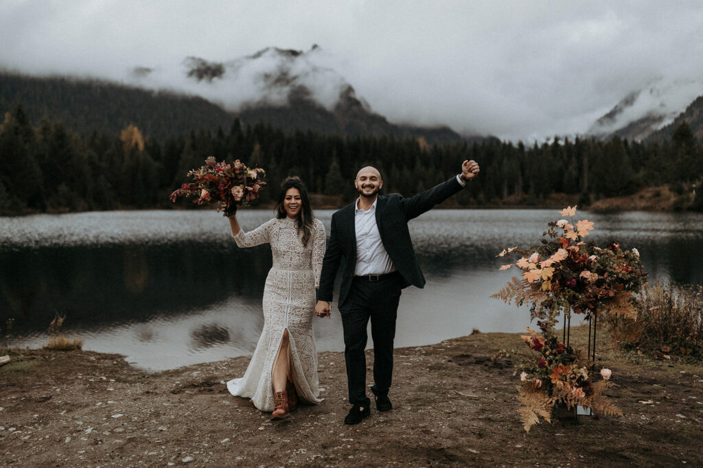 An eloping couple celebrating after their ceremony at Gold Creek Pond in Washington.