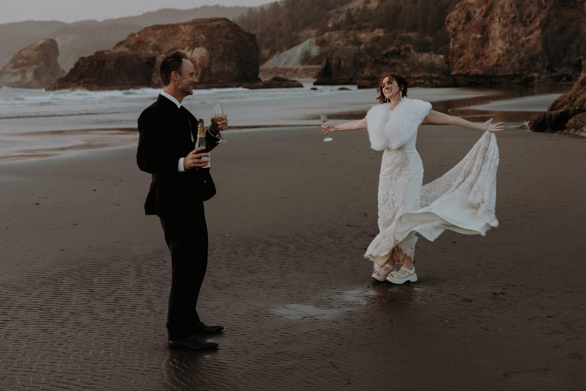 An elopement couple enjoying champagne at Meyers Creek Beach/Ariya's Beach in Southern Oregon.